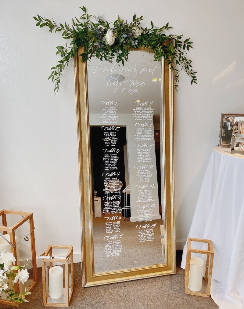A full length mirror with flowers and candles around it
