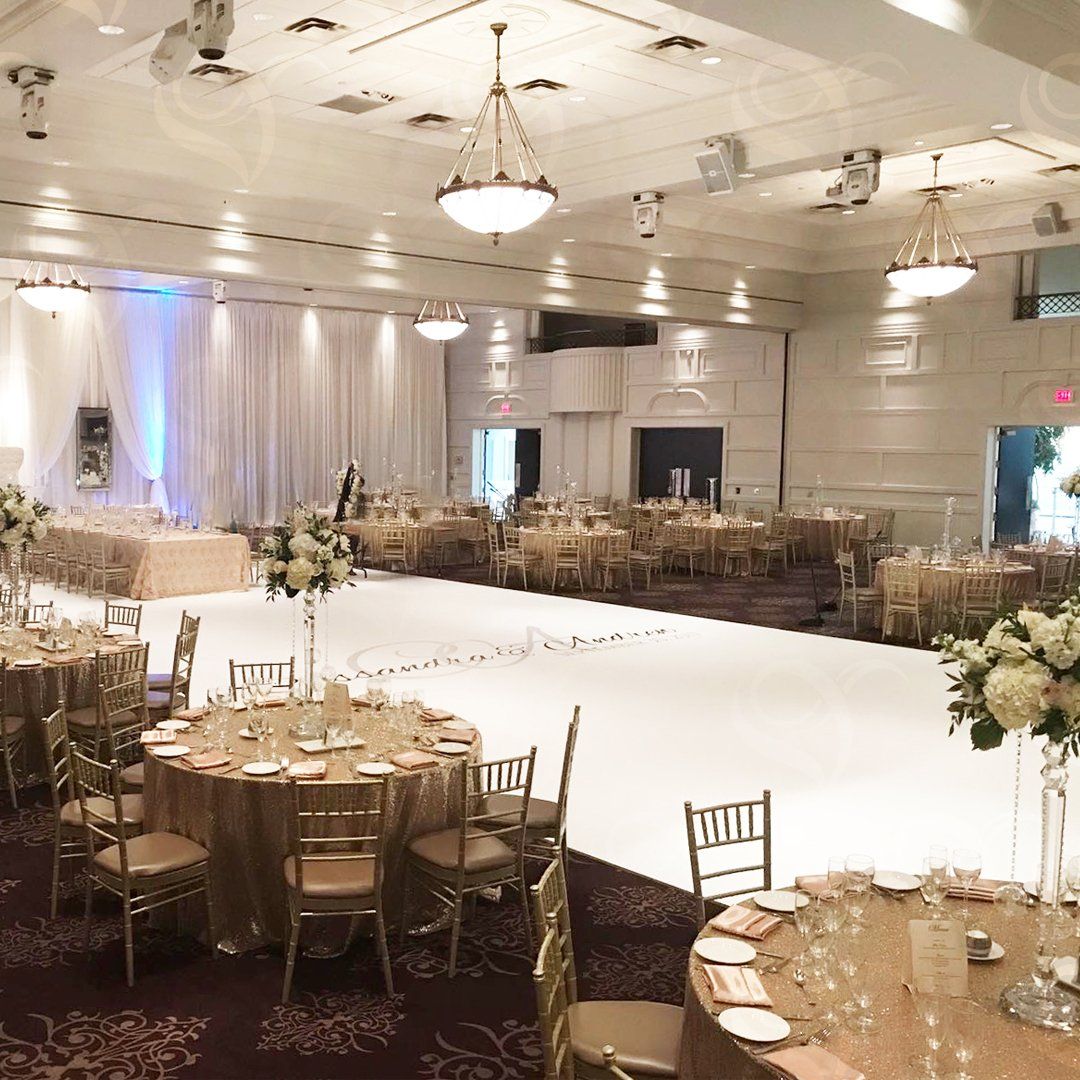 A large room with tables and chairs set up for a wedding reception.