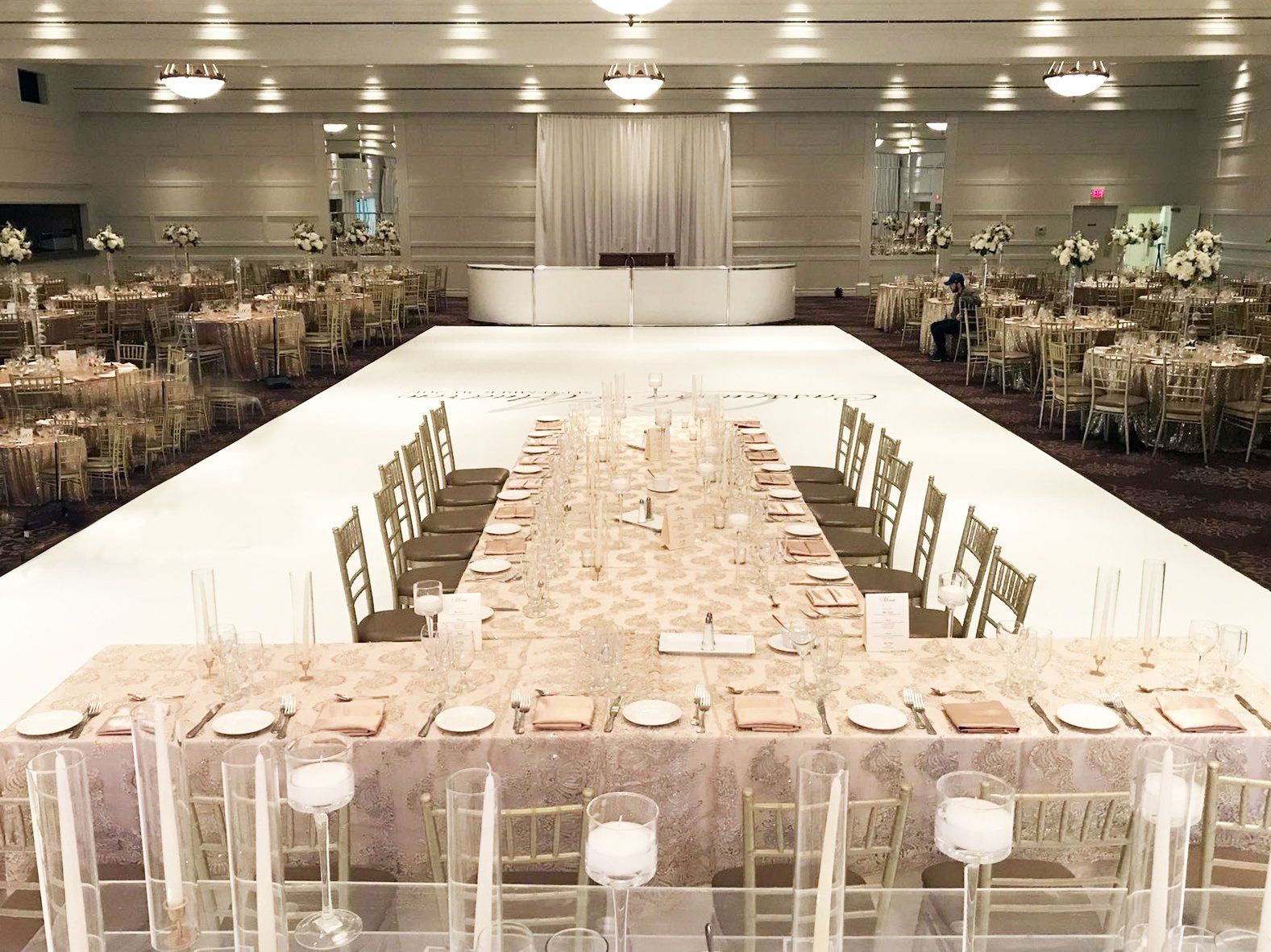 A long table in a large room with a white dance floor.