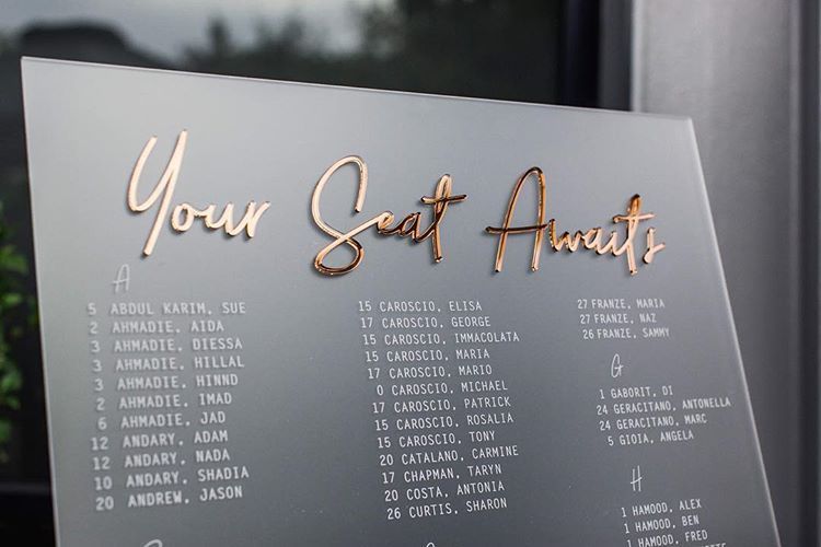 A sign that says `` your seat awaits '' is sitting on a table.