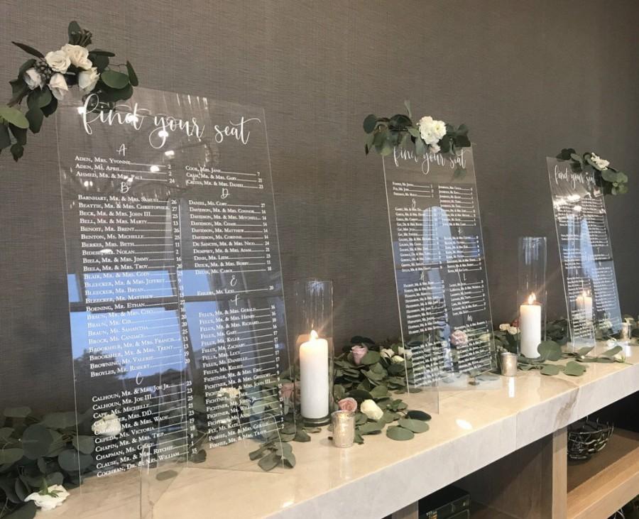 A table with a clear seating chart and candles on it