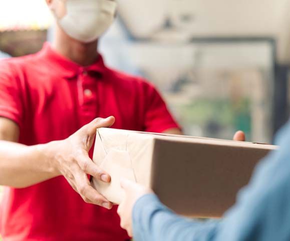 deliveryman wearing mask carry small box for delivery
