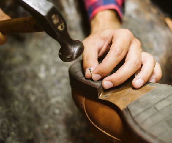 Craftsman repairing or making a pair of shoes.
