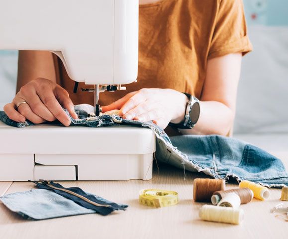 A woman tailor works at sewing machine