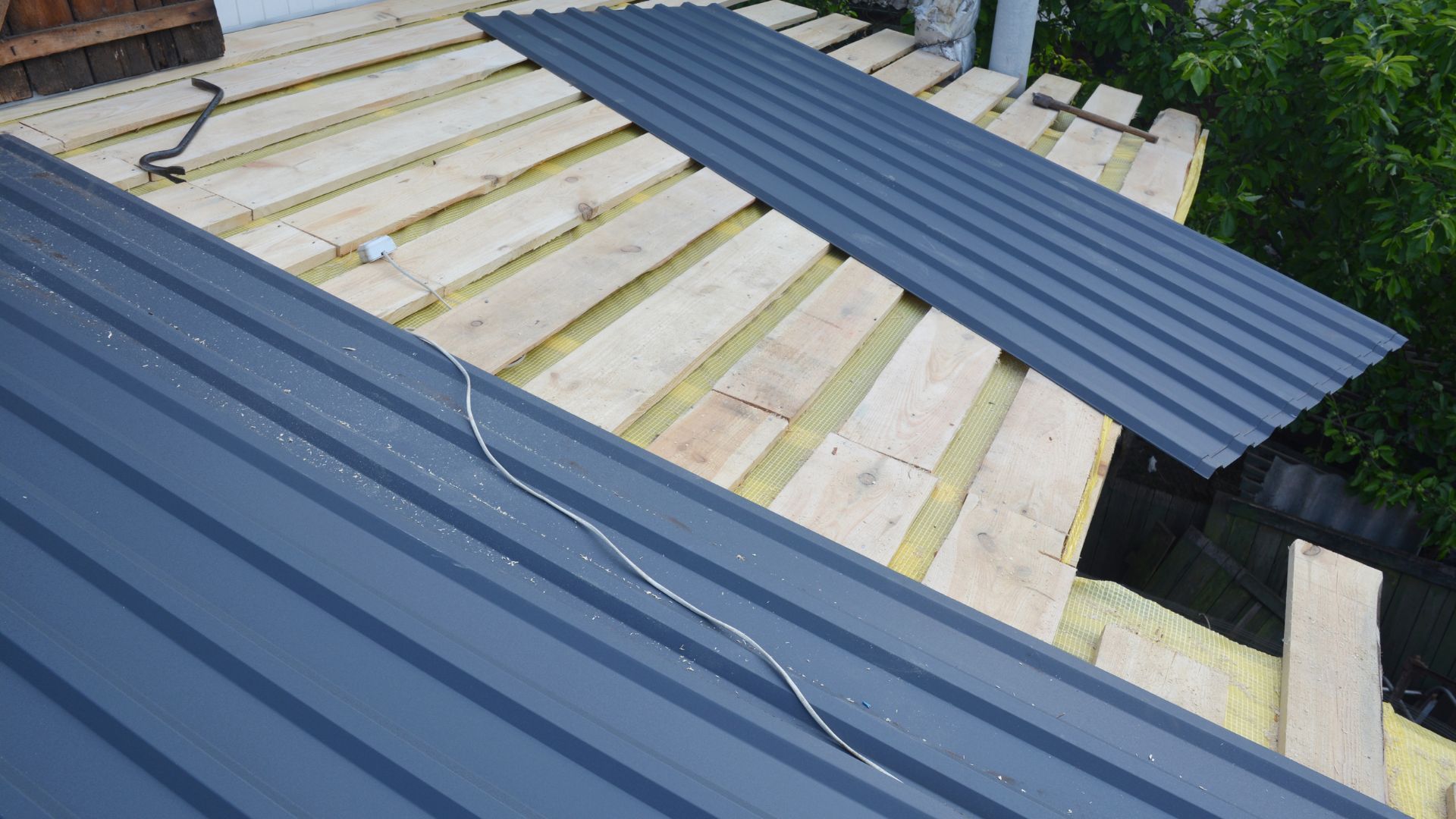 A metal roof is being installed on top of a wooden roof.