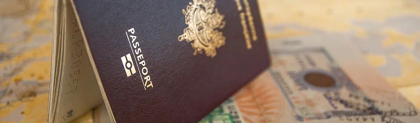 Passport on banknotes, with a gold emblem on a dark maroon cover.