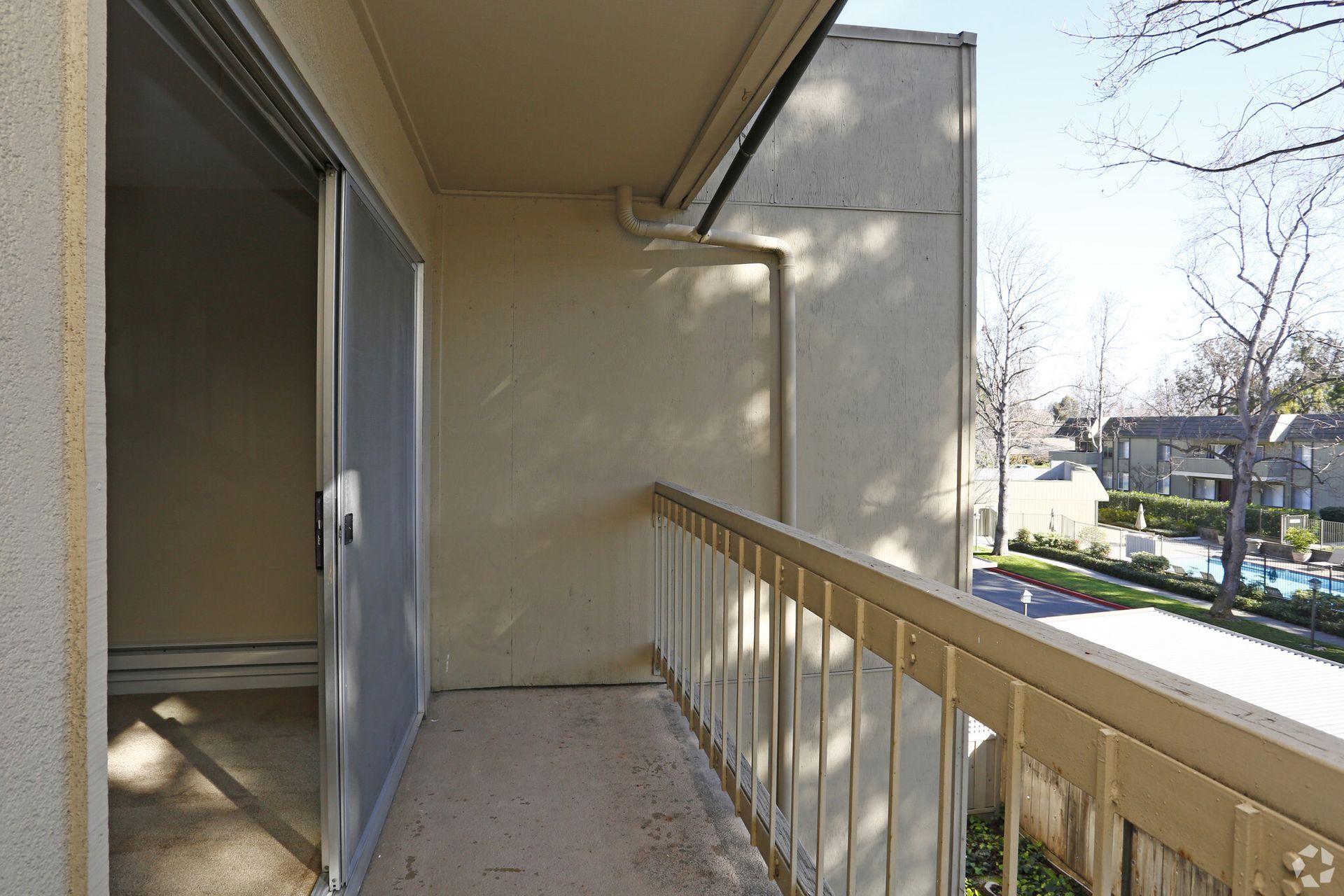 A balcony with a metal railing and sliding glass doors