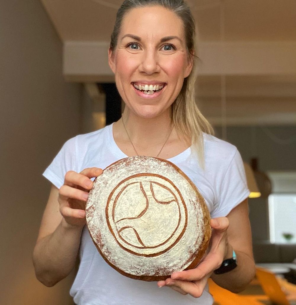 Dame som holder et brød der logo er risset inn i melet