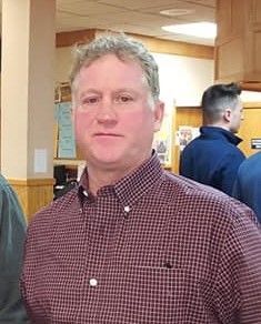 A man in a suit and tie is smiling for the camera.