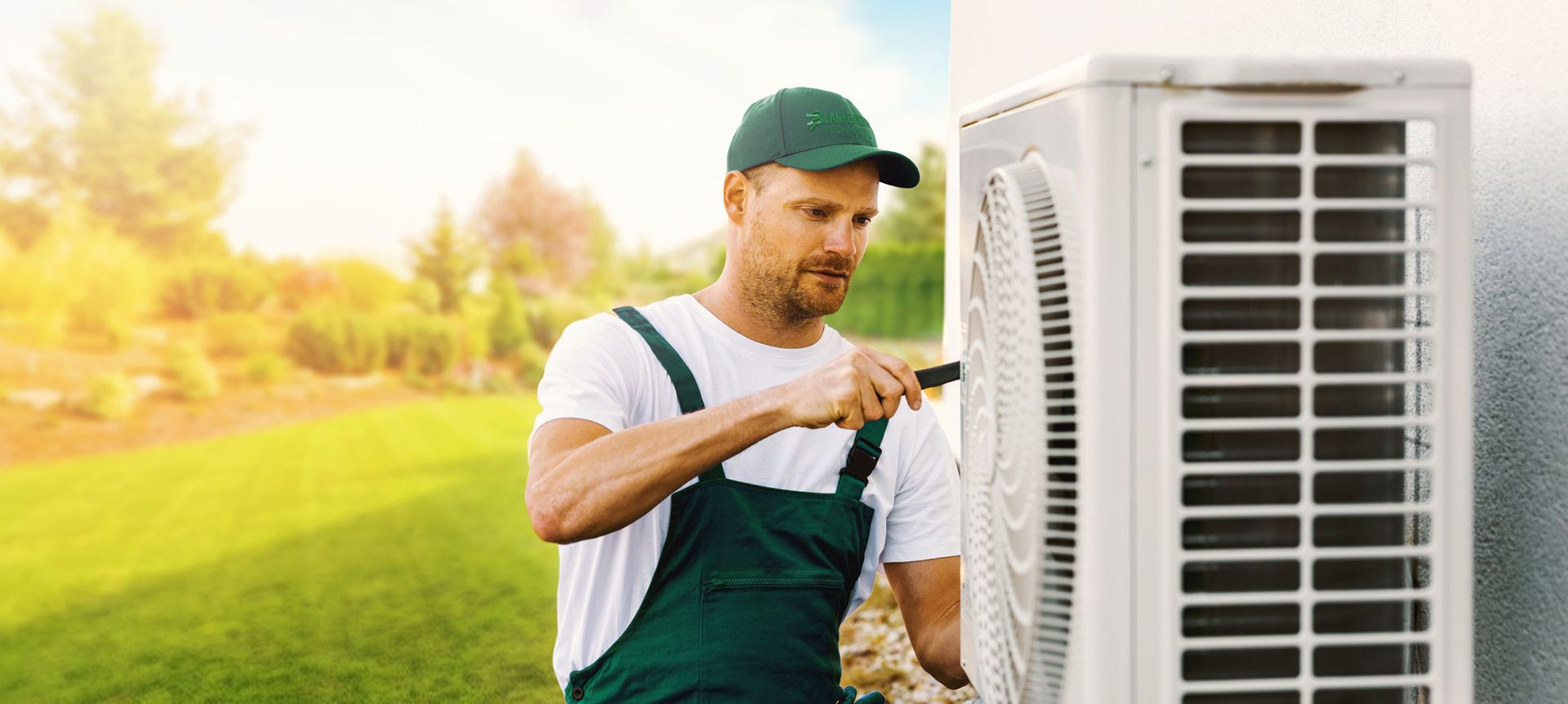 A man is working on an air conditioner outside of a building.