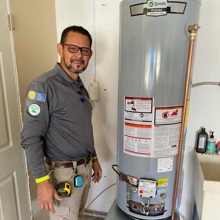 Jose Ruiz, founder of Ruiz Plumbing Industries, stands next to an AC Smith water heater.