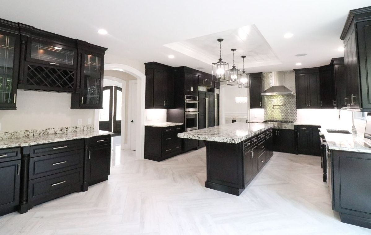 A kitchen with black cabinets and white counter tops