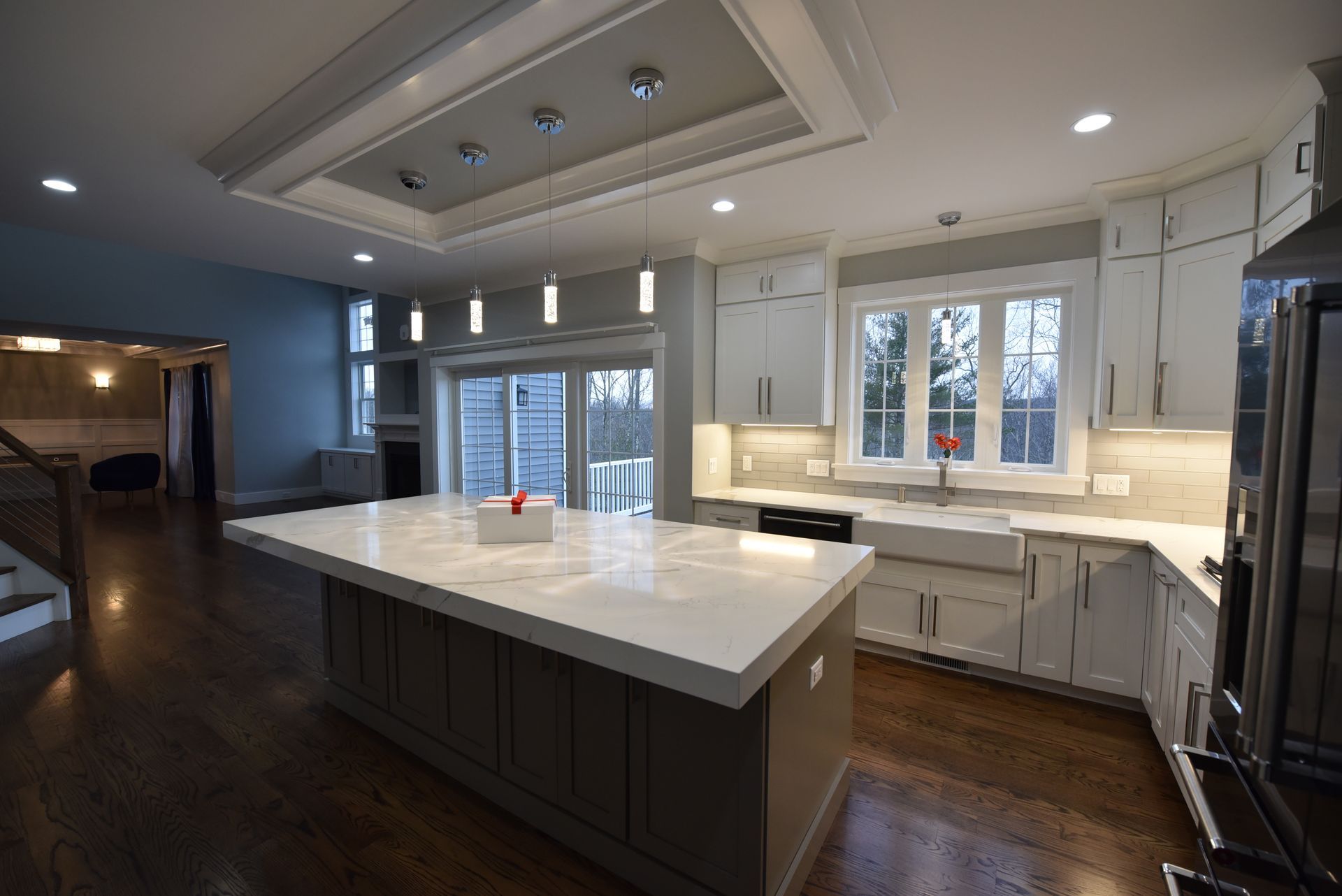 A kitchen with white cabinets and a large island in the middle.