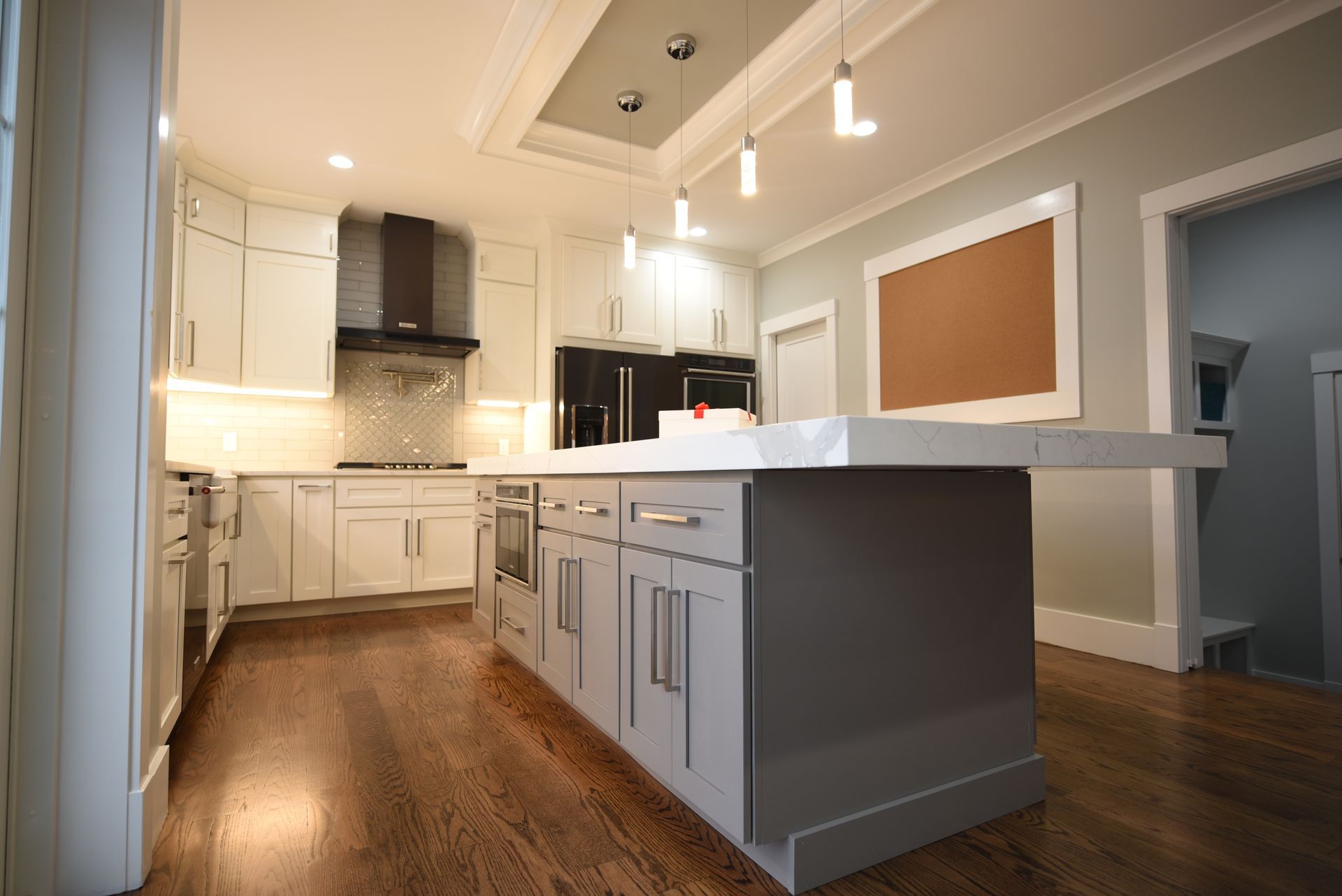 A kitchen with white cabinets and a large island in the middle.