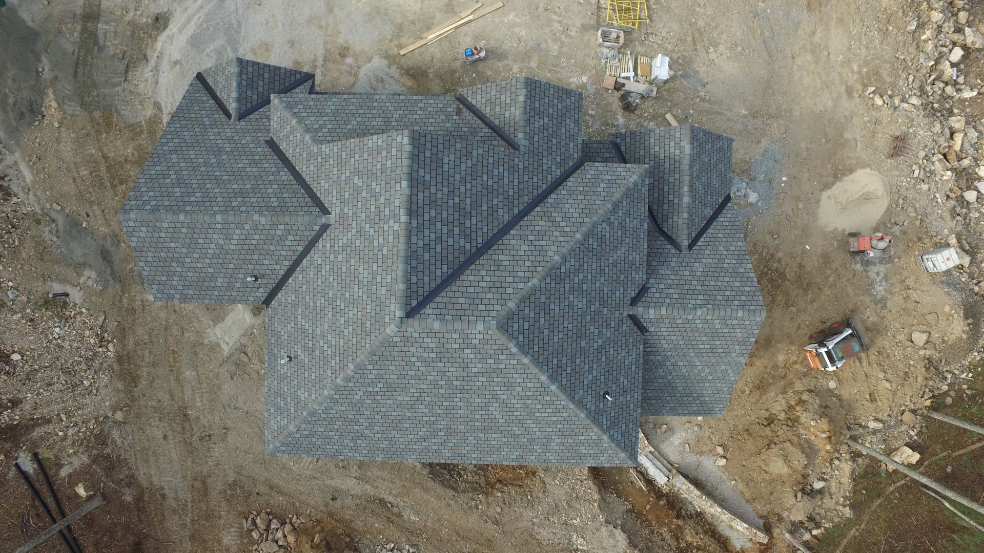 An aerial view of a house under construction with a roof that is being built.