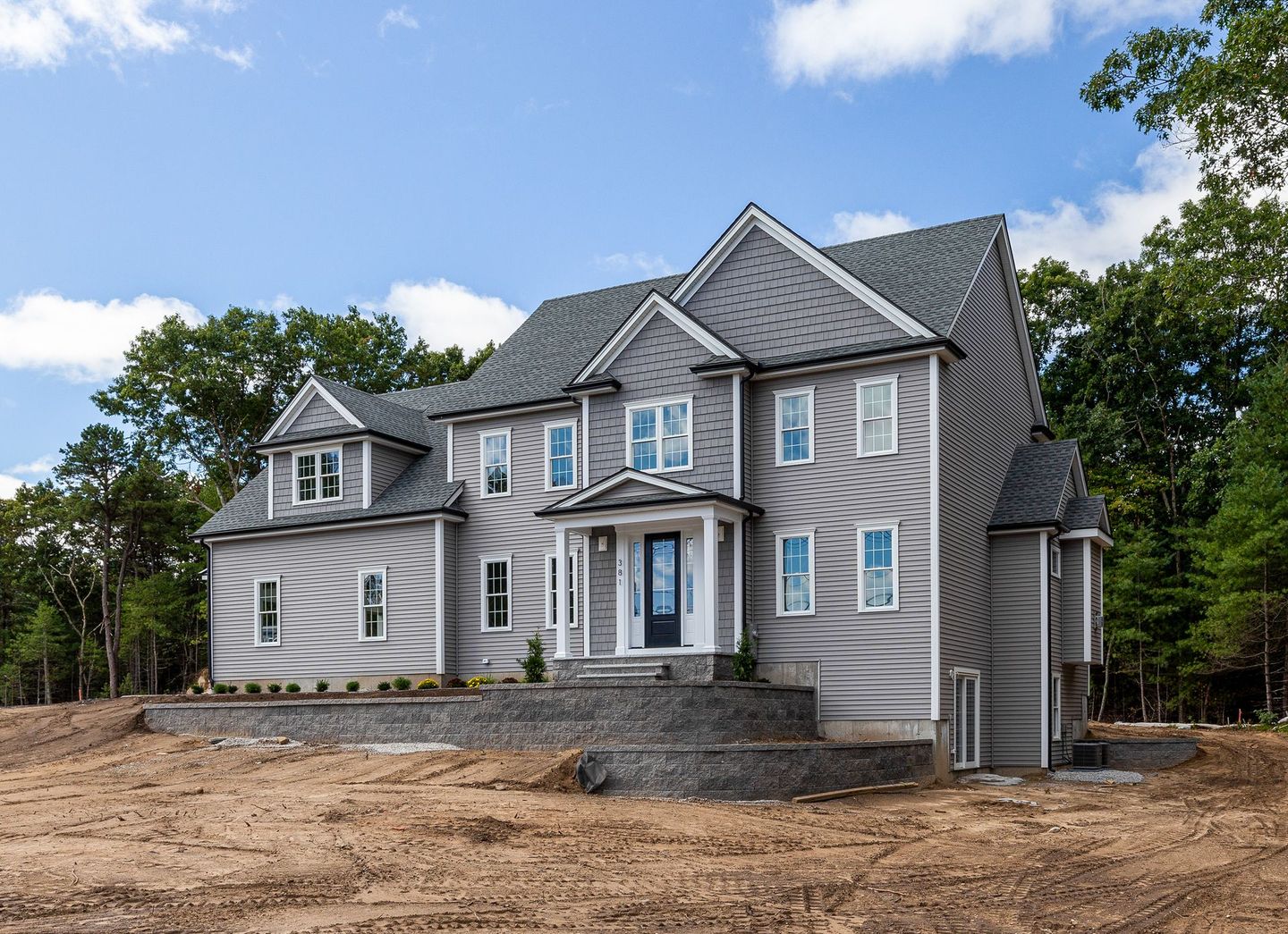 A large house is sitting on top of a dirt field.