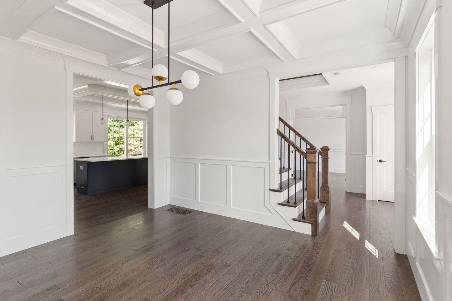 An empty dining room with hardwood floors and a staircase in a house.