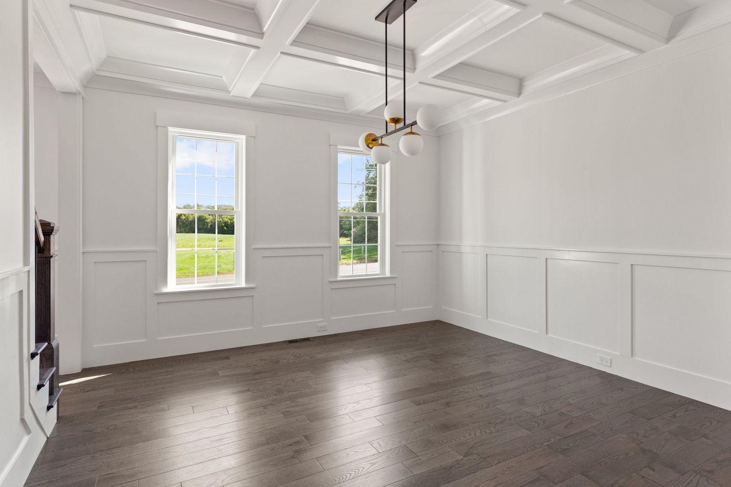 An empty room with hardwood floors and white walls