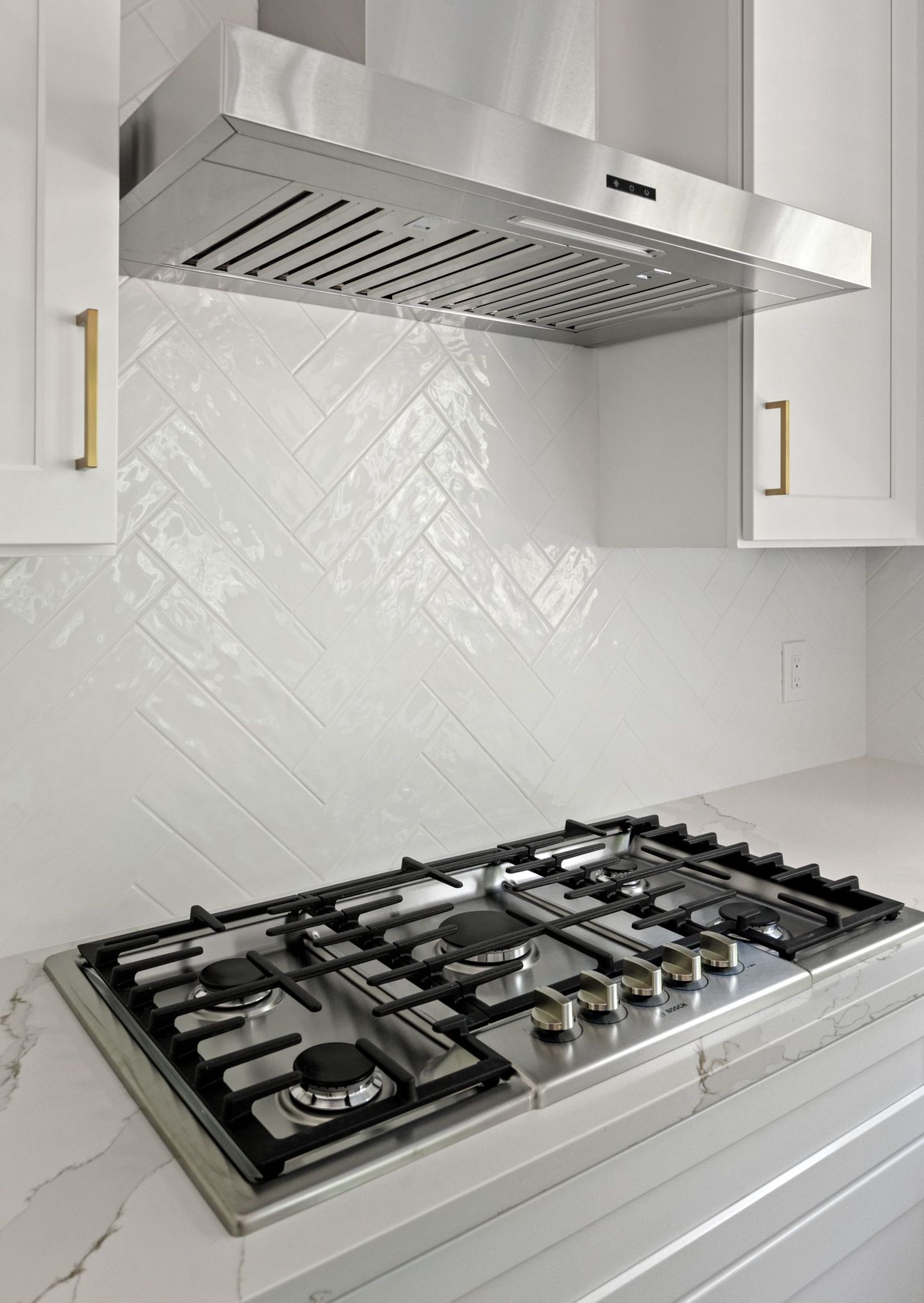 A stove top oven with a hood above it in a kitchen.