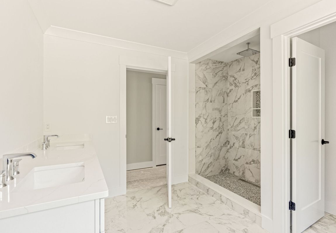 A bathroom with a sink and a walk in shower.