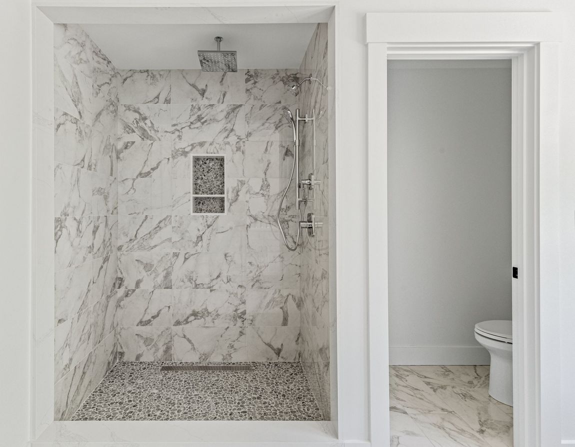 A bathroom with a walk in shower and a toilet.