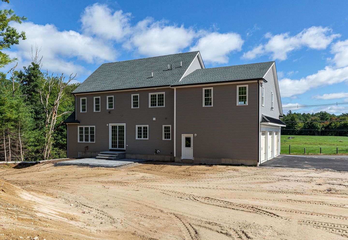 A large house is sitting in the middle of a dirt field