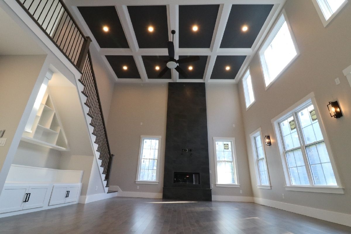 An empty living room with a fireplace and stairs