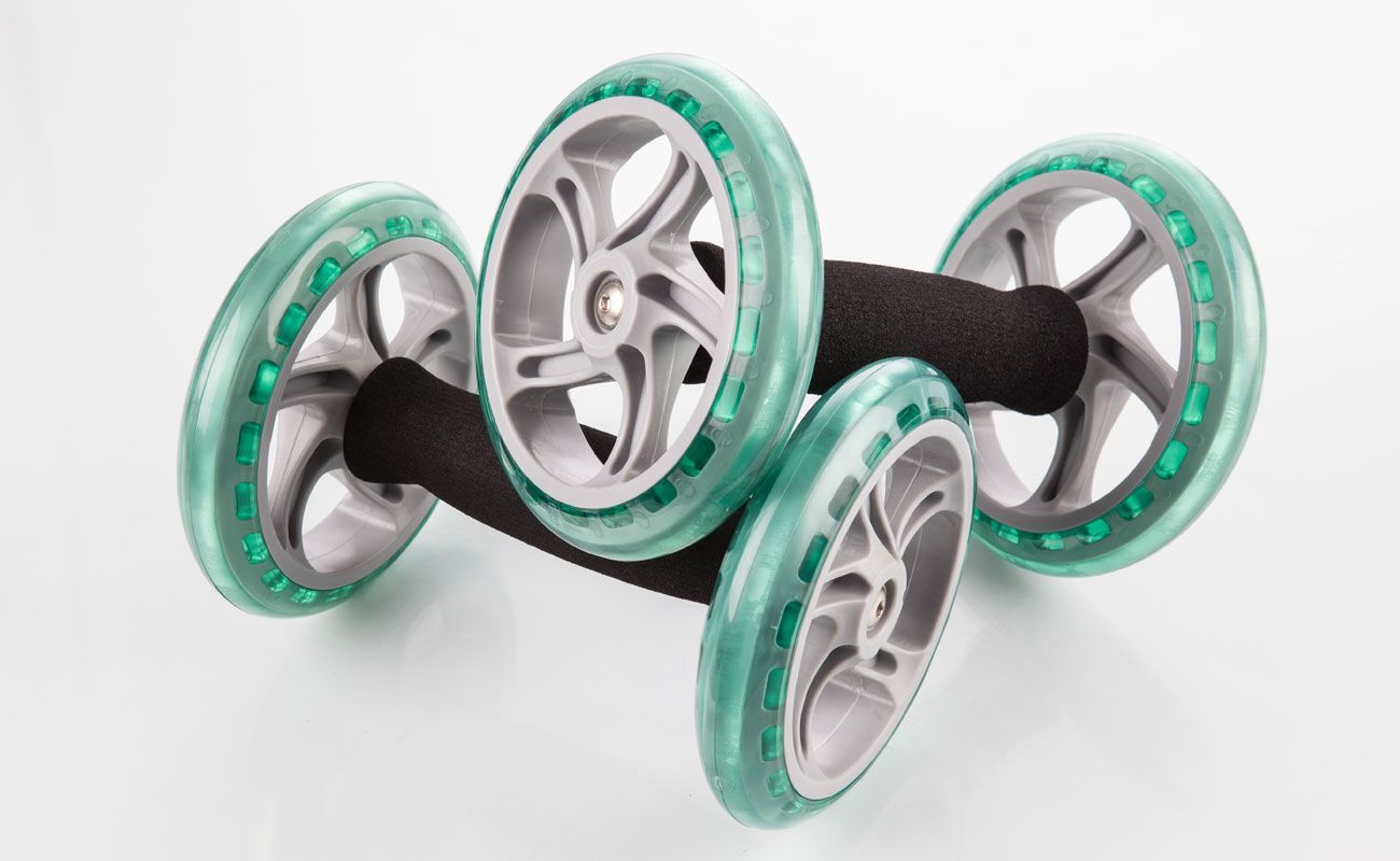 A pair of roller skates with green wheels on a white surface.