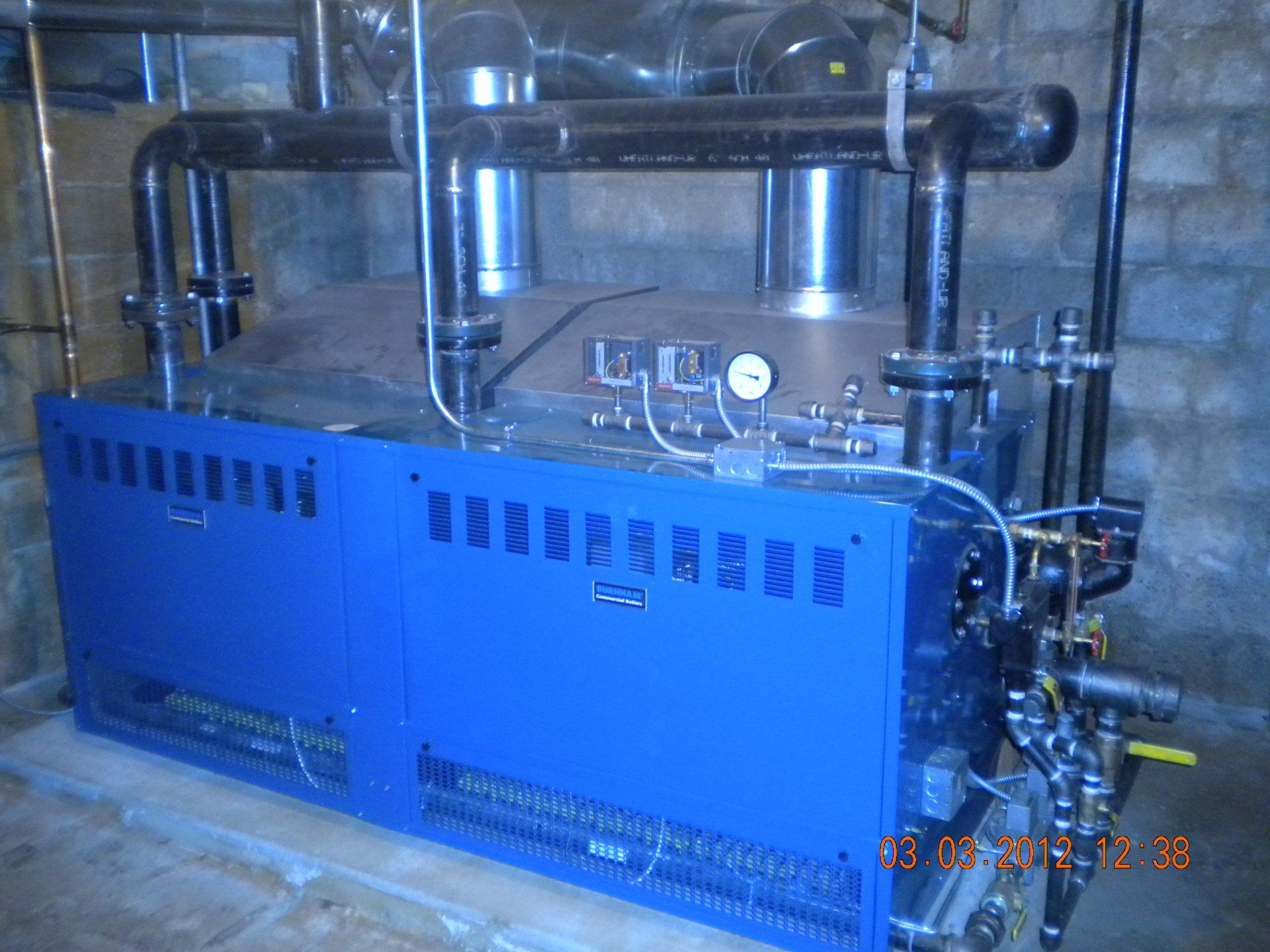 Blue commercial boiler in a basement.