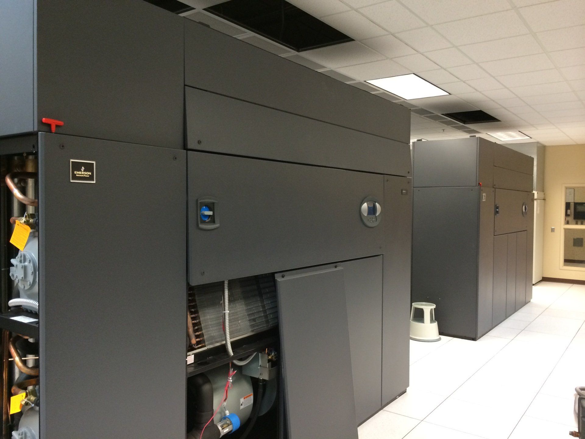 Dark grey server racks in a data center; one with an open panel revealing internal components.