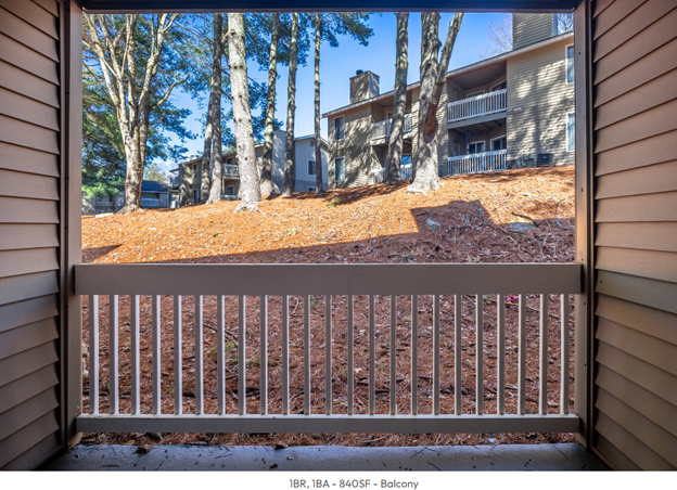 A balcony with a view of trees and a building