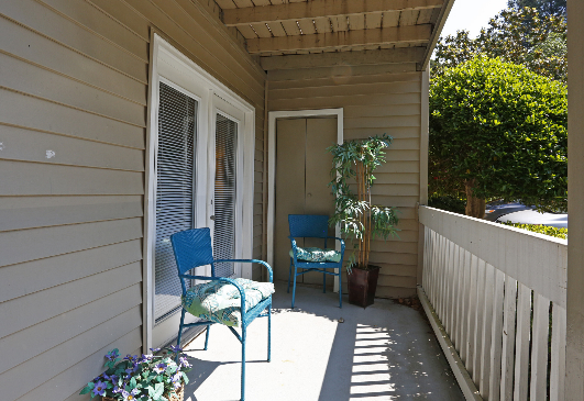A balcony with two chairs and a potted plant