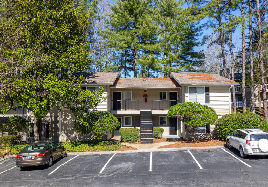 A large apartment building with cars parked in front of it.
