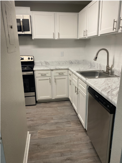 A kitchen with white cabinets and stainless steel appliances