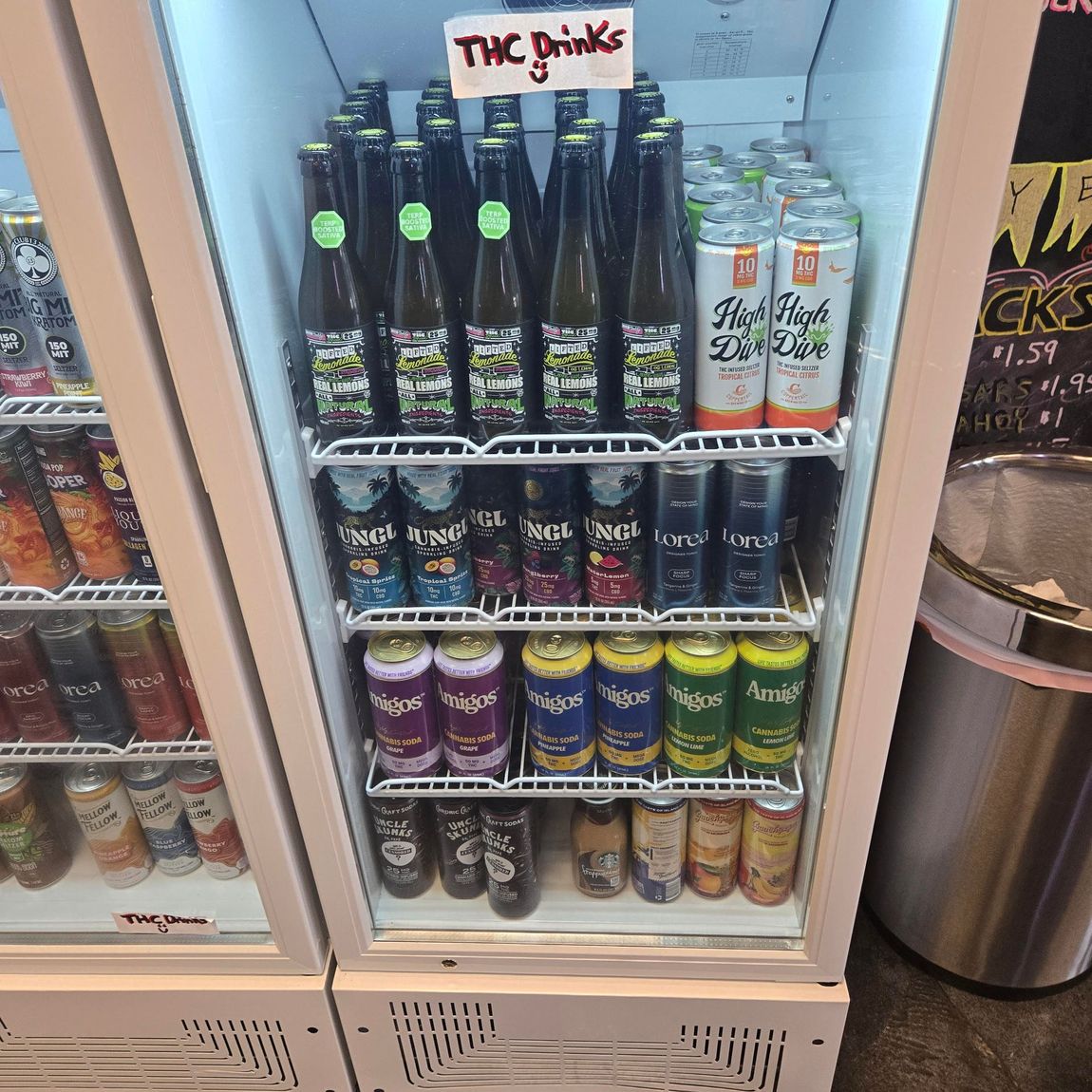Mini fridge of colorful canned and bottled drinks in a convenience store display