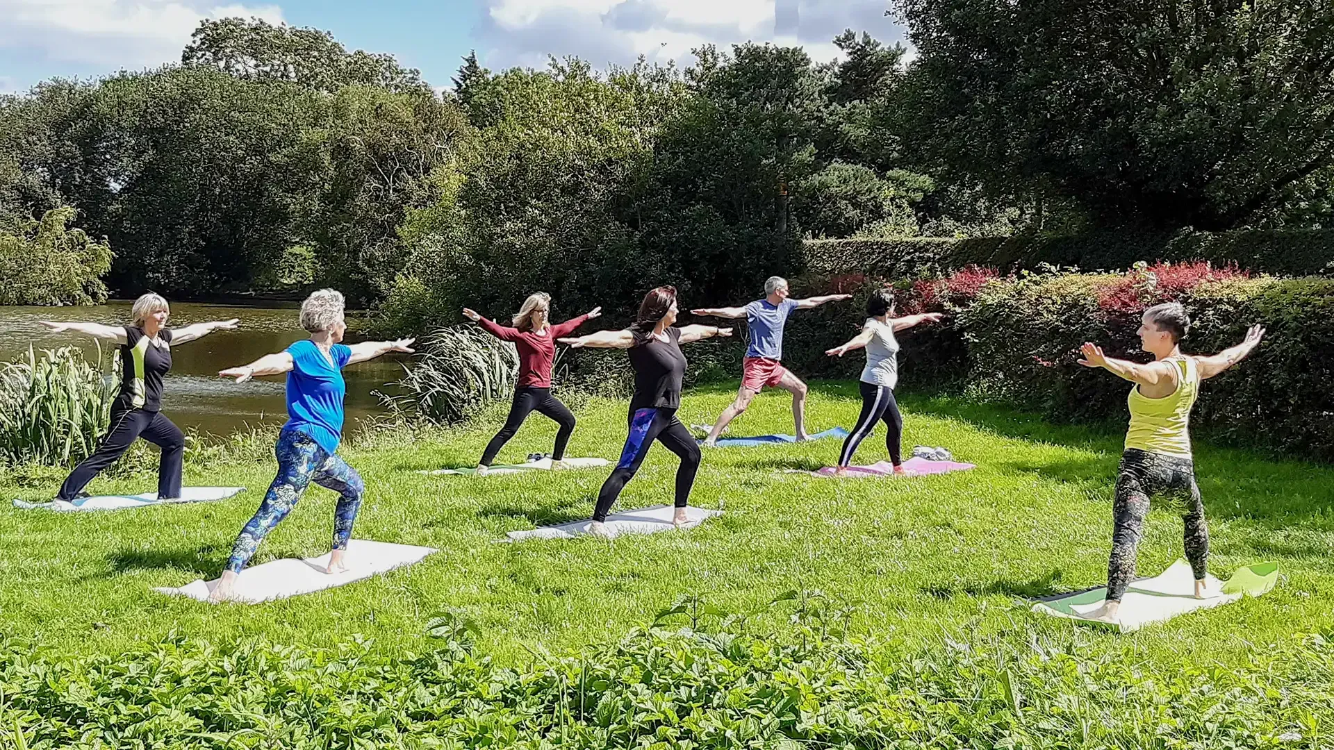 Group of people enjoying an uplifting outdoor yoga session.