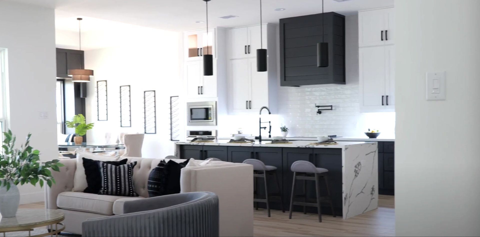 A living room with a couch and a kitchen in the background.