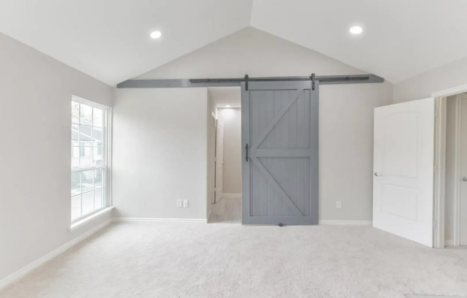 An empty room with a sliding barn door