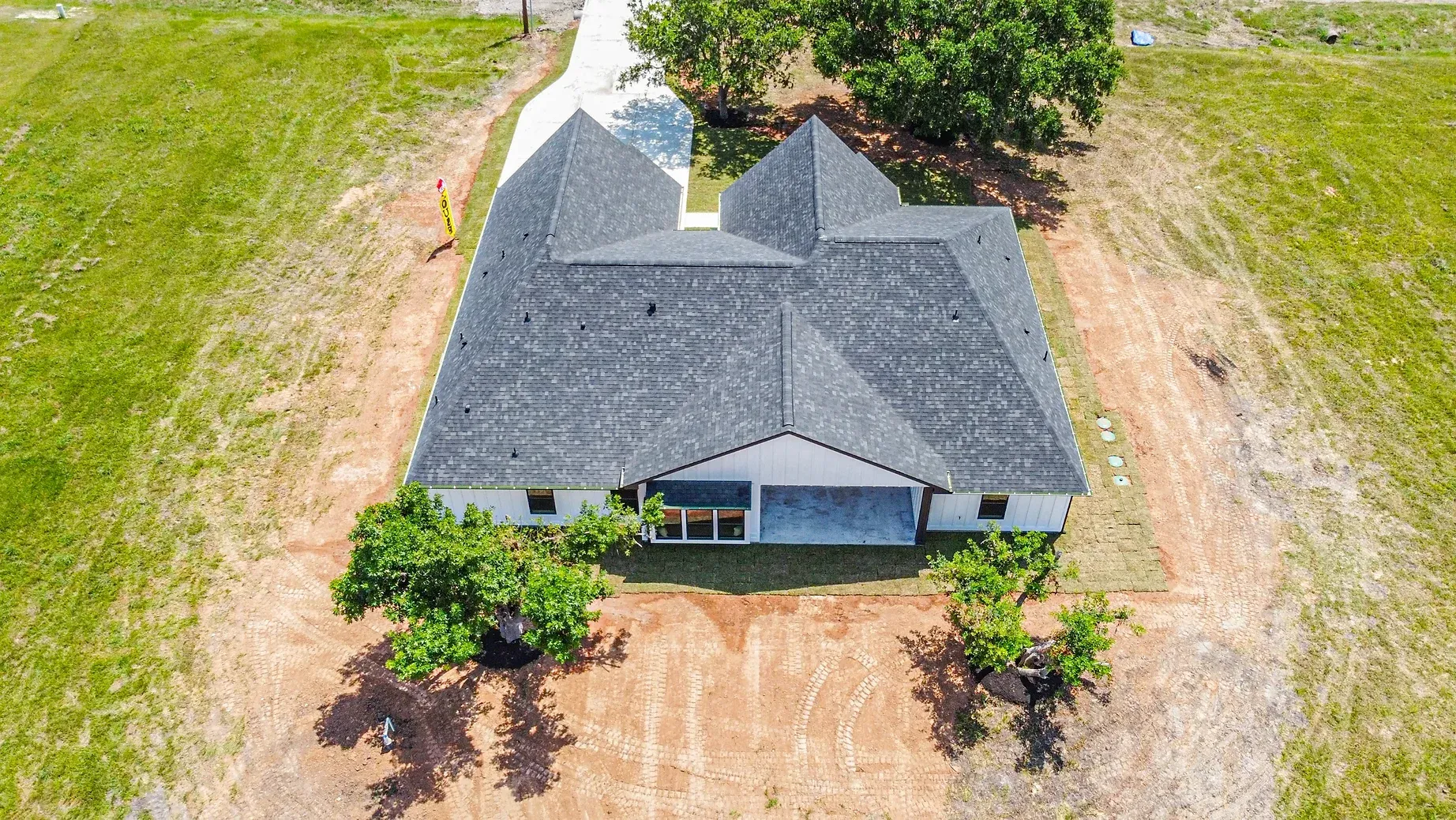 An aerial view of a house with a gray roof and a garage.