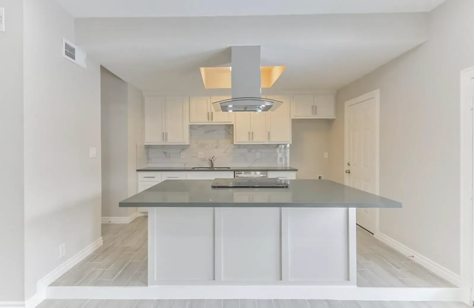 An empty kitchen with a large island in the middle