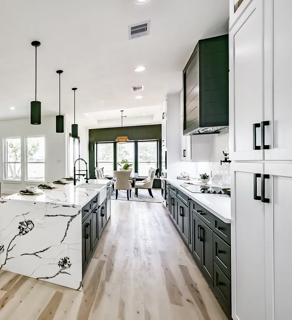 A kitchen with a large island in the middle and white cabinets.