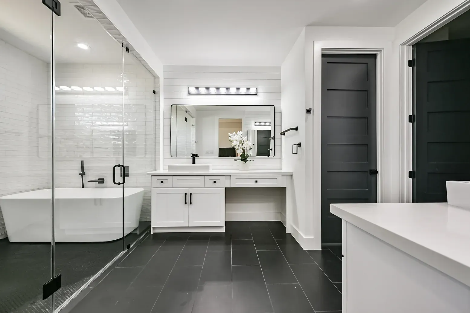 A bathroom with a tub , sink , mirror and walk in shower.