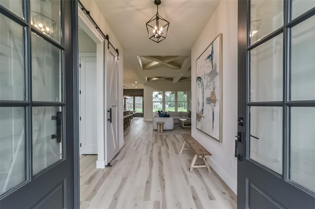 A hallway with hardwood floors and a painting on the wall.