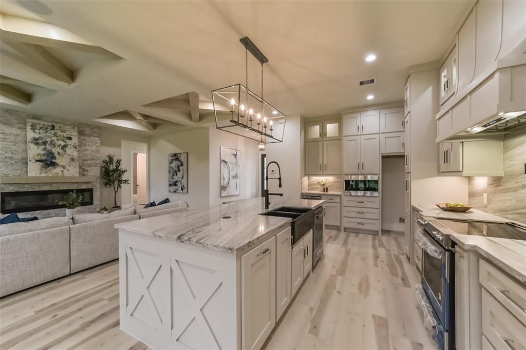 A kitchen with a large island and white cabinets
