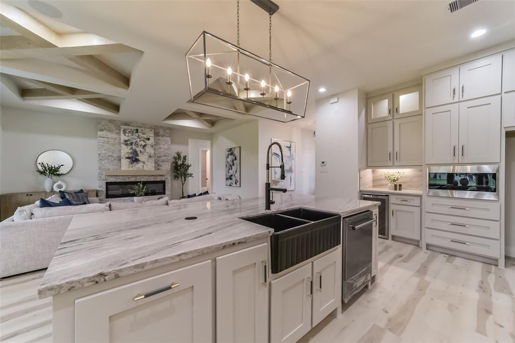 A kitchen with white cabinets and a black sink.