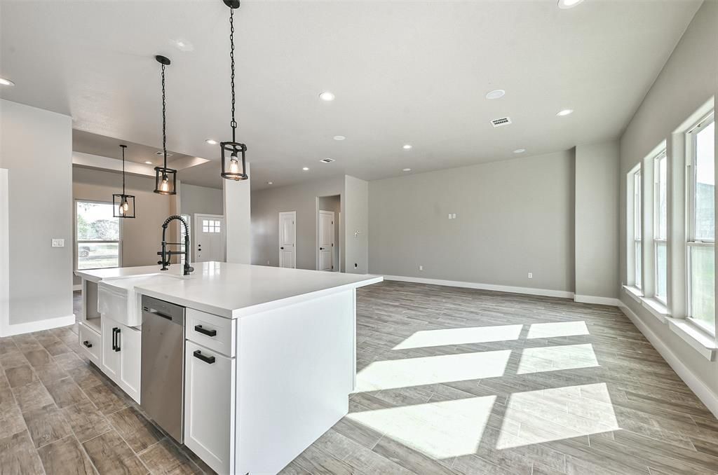 An empty kitchen with a large island in the middle of the room.