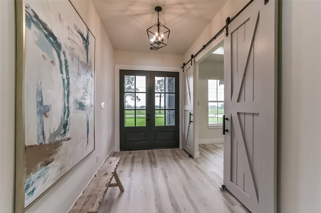 A hallway with sliding barn doors and a painting on the wall