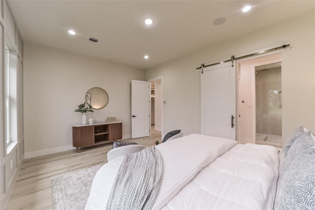 A bedroom with a large bed and a sliding barn door
