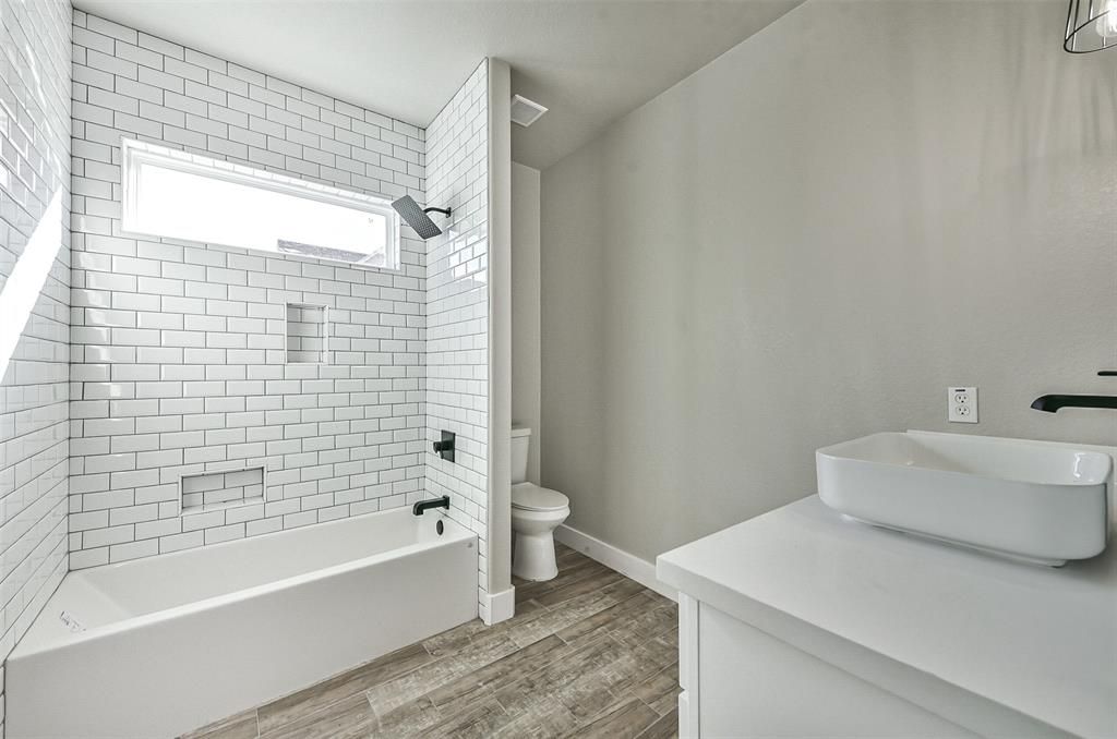 A bathroom with a tub , sink , toilet and shower.