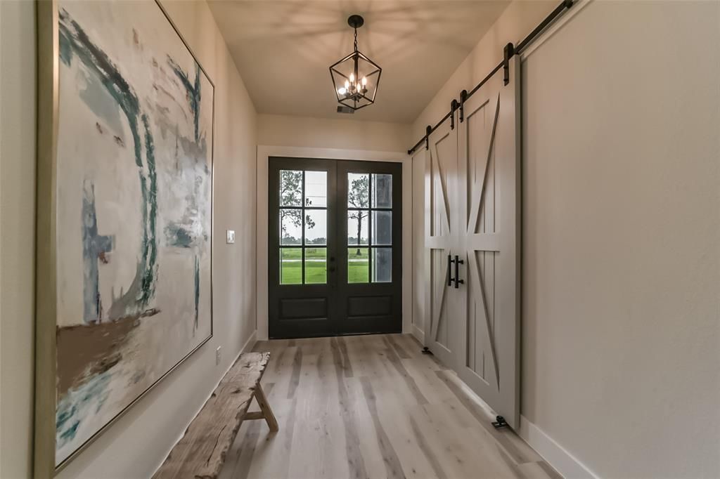 A hallway with sliding barn doors and a painting on the wall